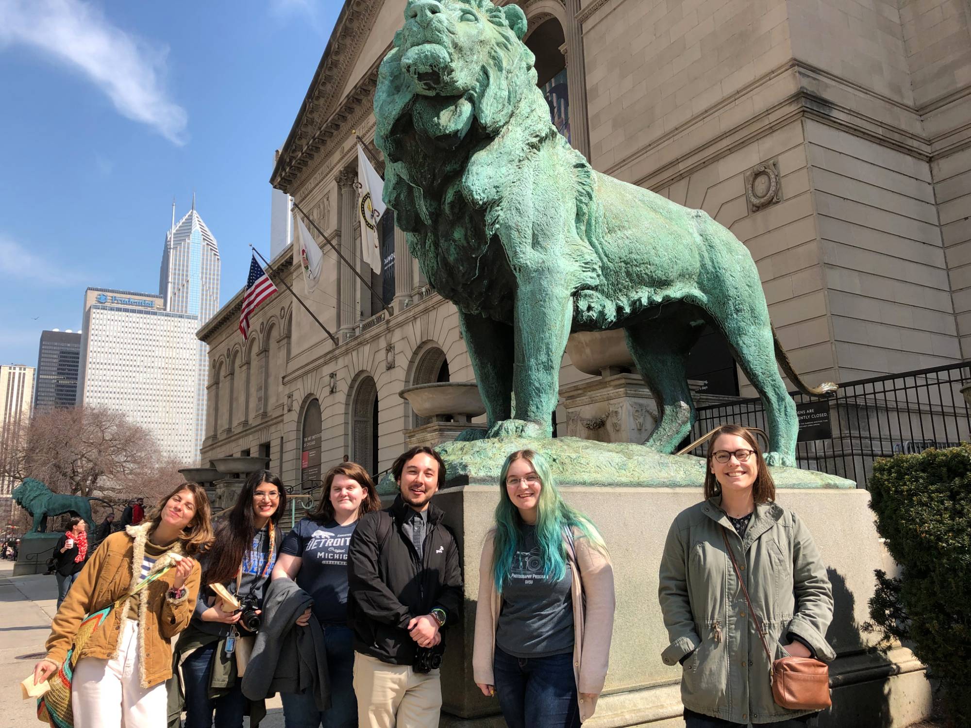 Group of students gathered at the Art Institute by the lion.